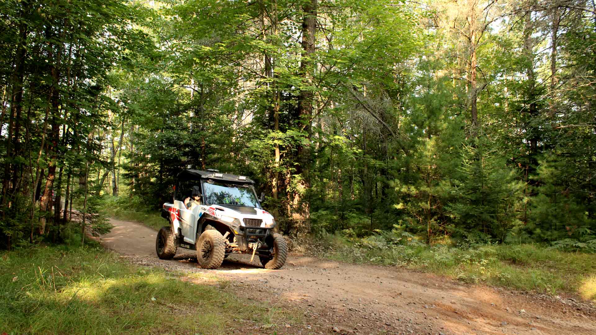 ATV driving on trail through forest of Lakeland ATV Club trails in Vilas County, Wisconsin
