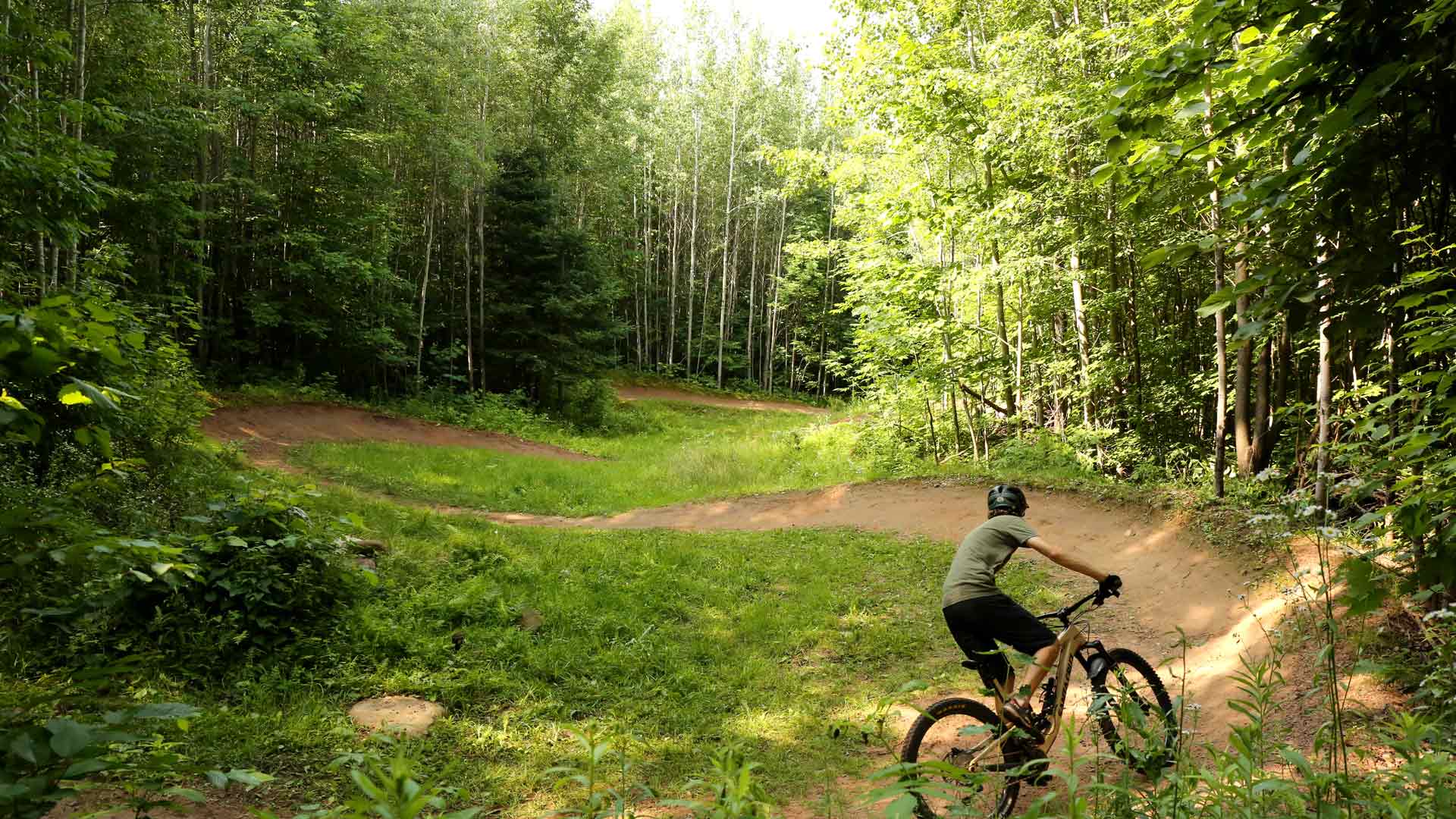 Person biking through a path in the woods of WinMan Trails in Vilas County, Wisconsin