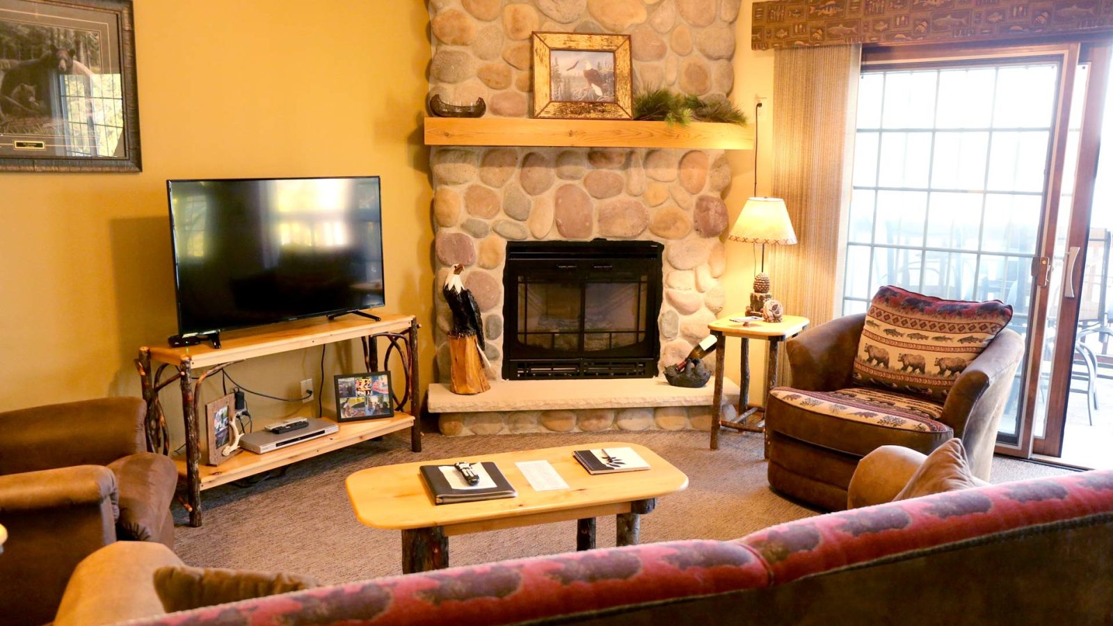 Lodge interior with fireplace, couch, recliner, and television