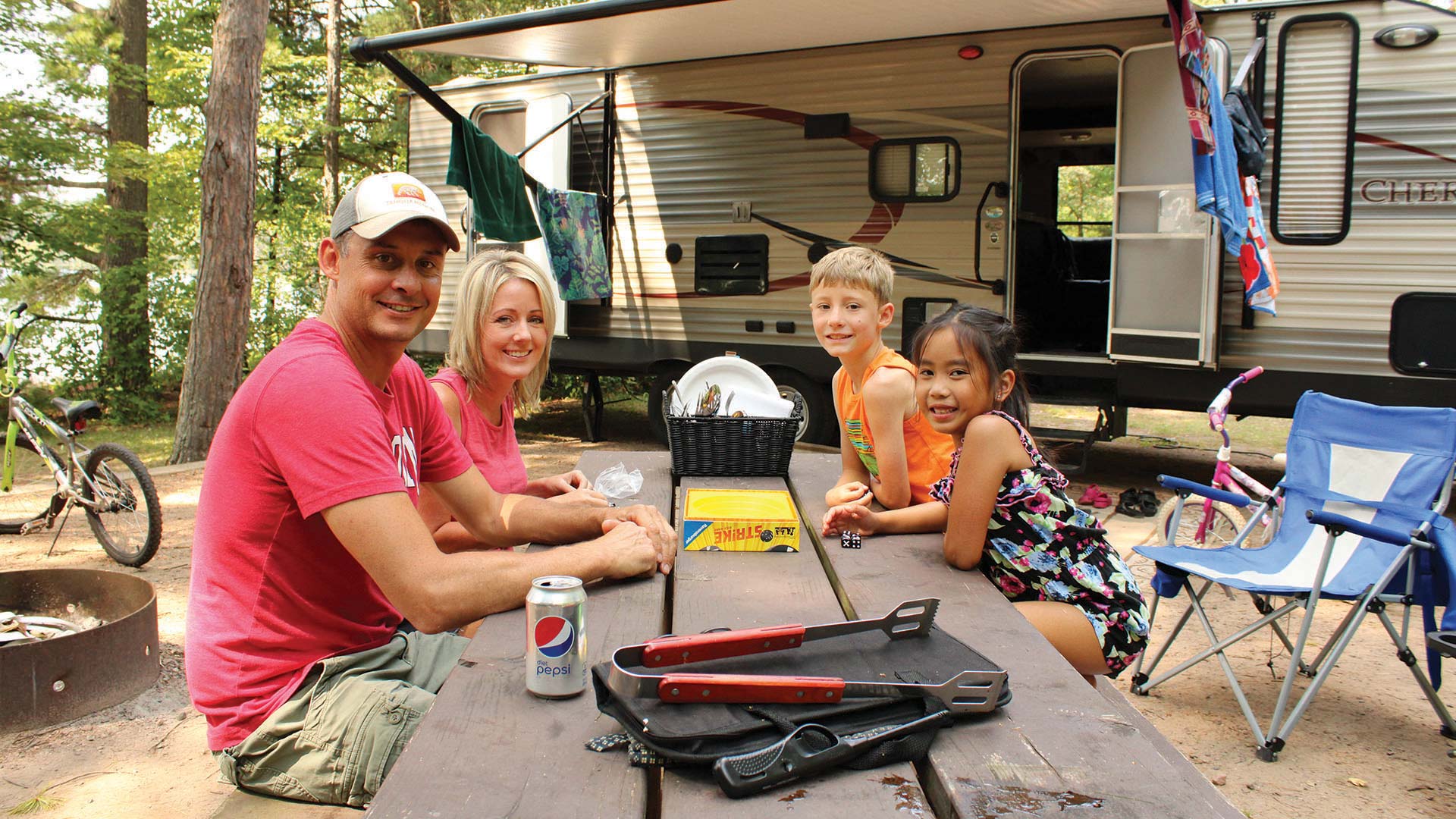 Family sitting around a picnic table at Crystal Lake Campground