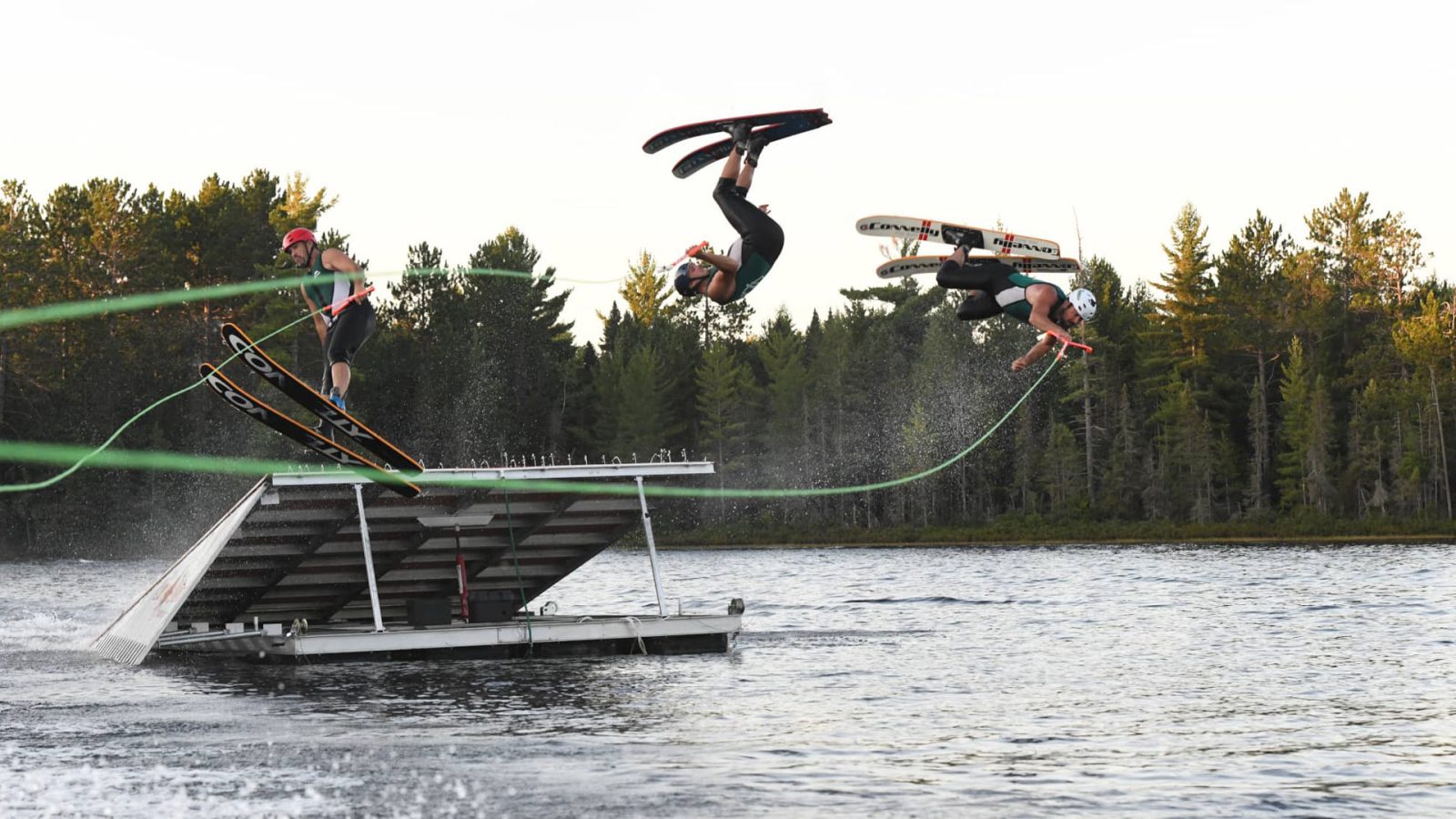 Skiers going over a jump at Conover Chain Skimmers water ski show Vilas County WI