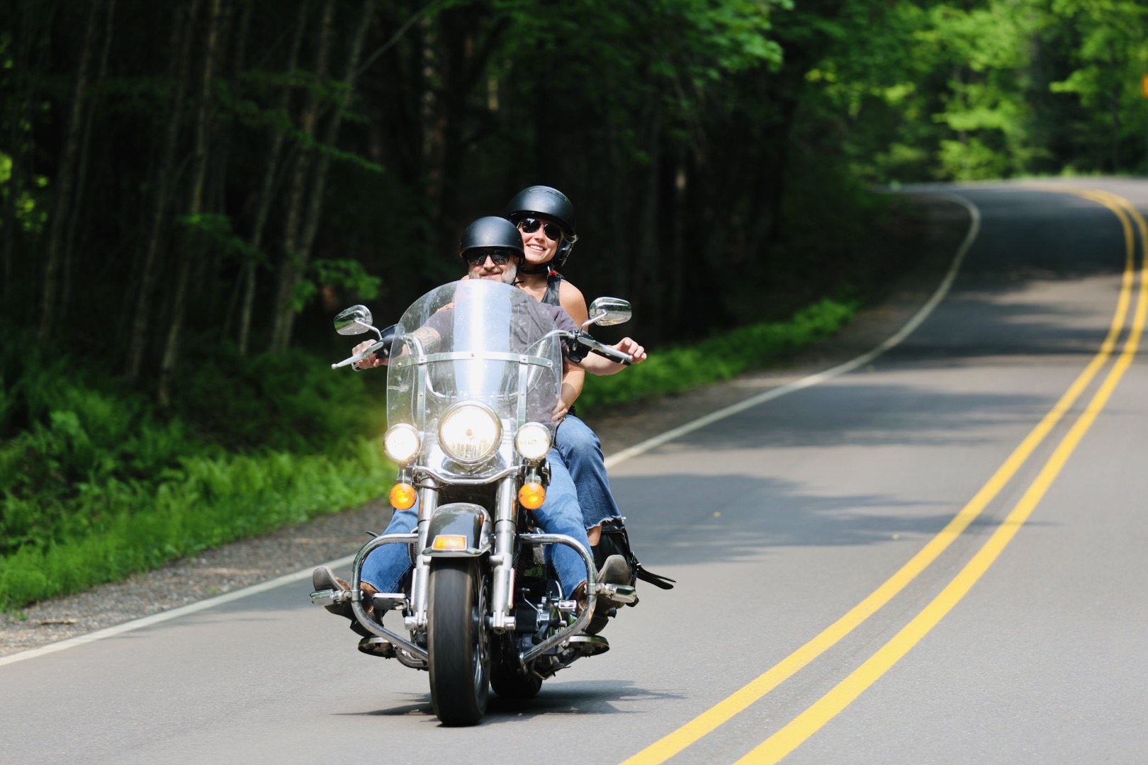 Couple riding motorcycle along a Vilas County Road lined by trees