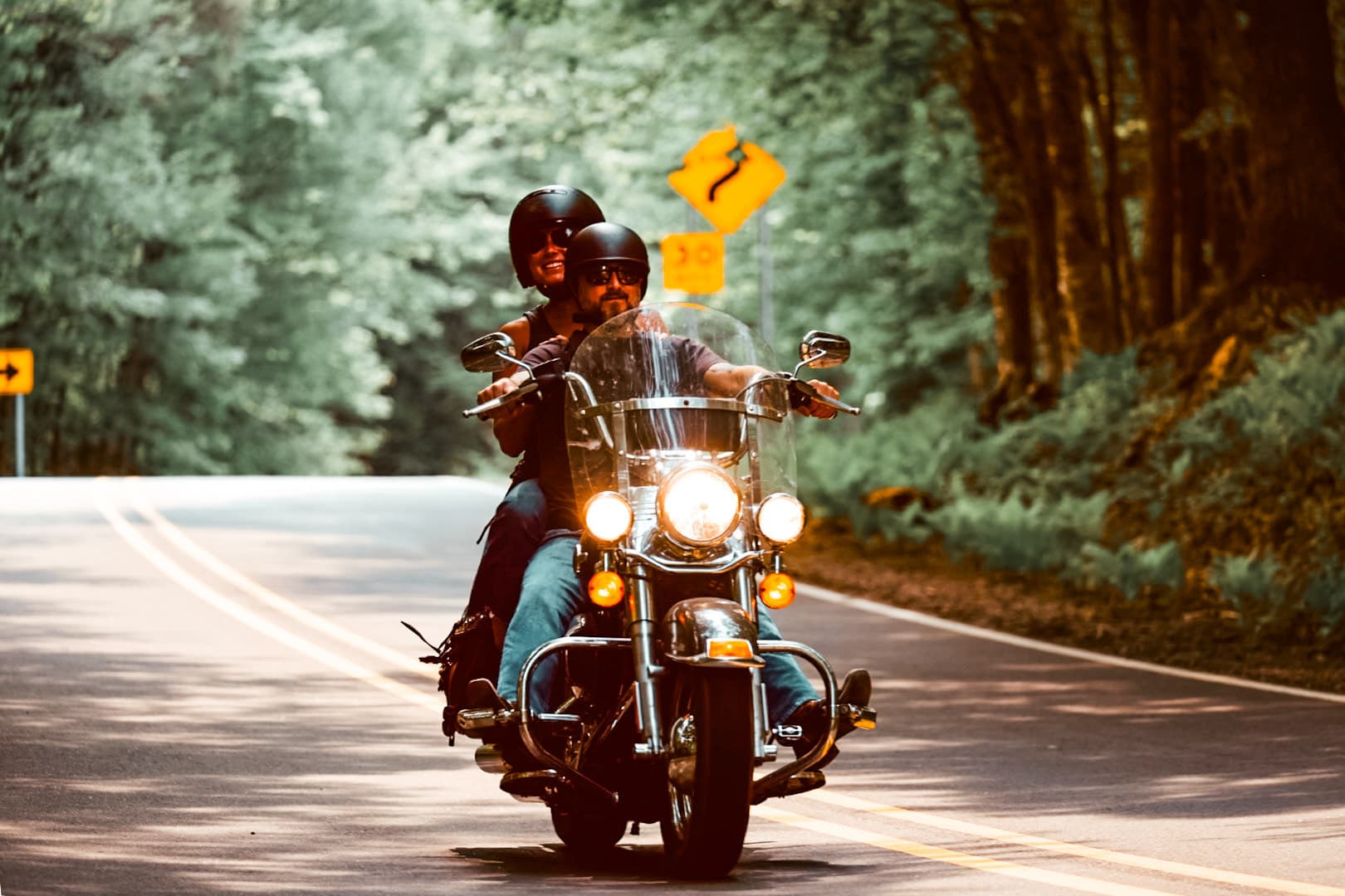 Couple riding motorcycle along a Vilas County Road lined by trees