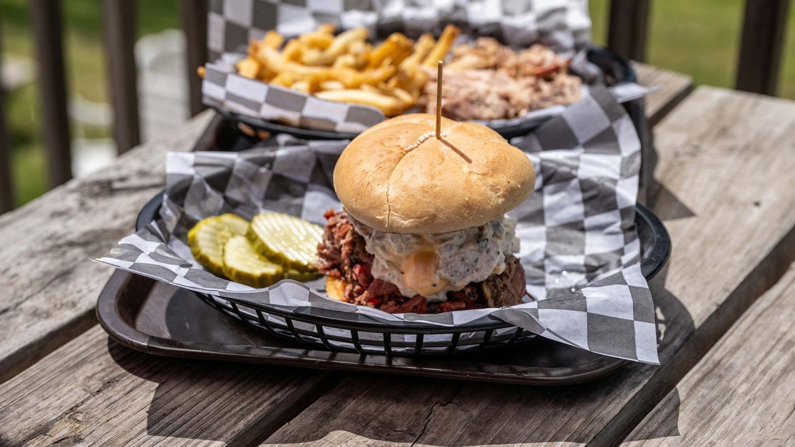Sandwich and fries on a table outside at Bad Bones BBQ
