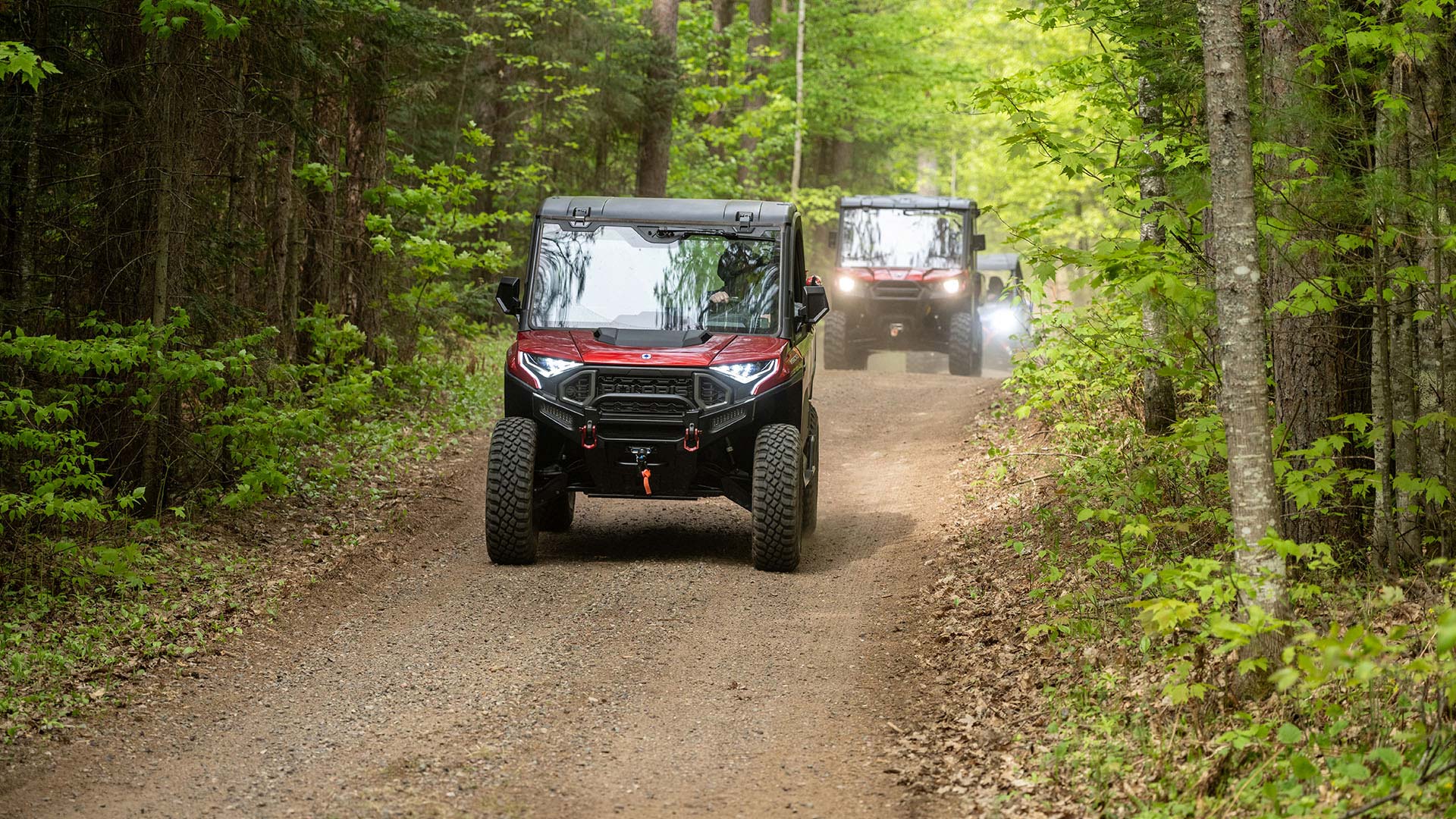 UTVs driving down a dirt trail - Lakeland Power Sports